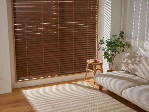 ウッドブラインドの羽根の隙間から少し光が入っている