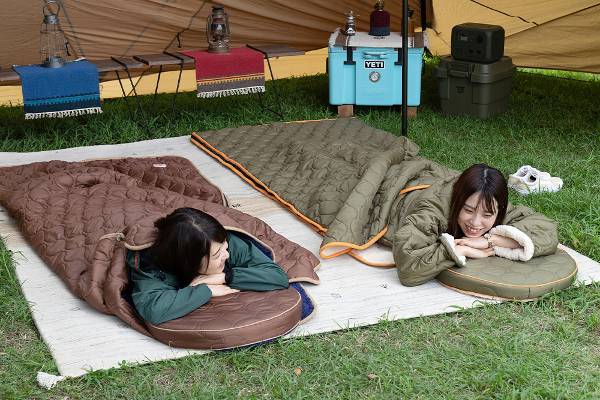 キャンプのテントで寝転んで寛ぐ女性