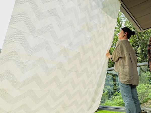 サンシェードの日陰に立つ女性