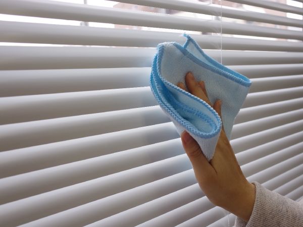布巾でブラインドを掃除しているところ