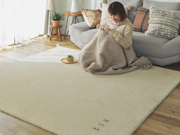 おしゃれなウールラグの上で寛ぐ女性