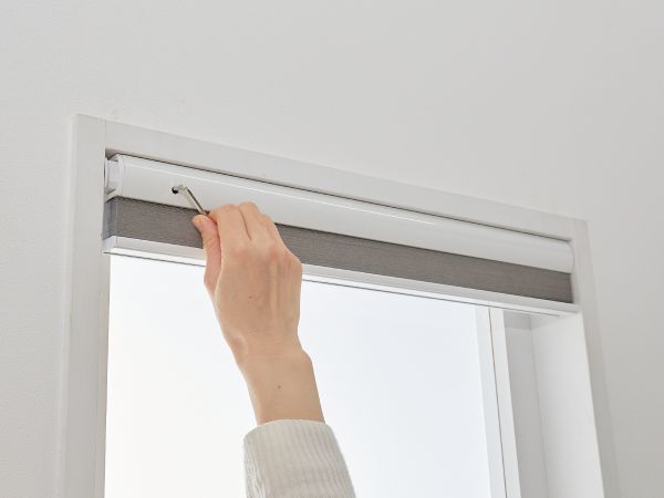 つっぱりハニカムスクリーンをレンチで固定している