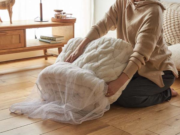 白いこたつ布団を洗濯ネットに入れているところ
