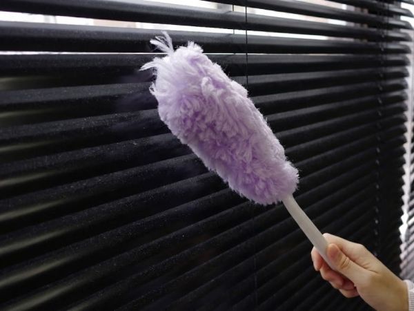 黒のブラインドを掃除している様子