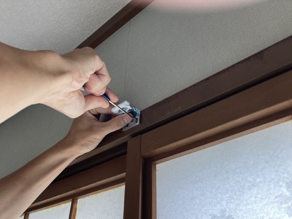 鴨居の上にハニカムスクリーンのブラケットを設置している