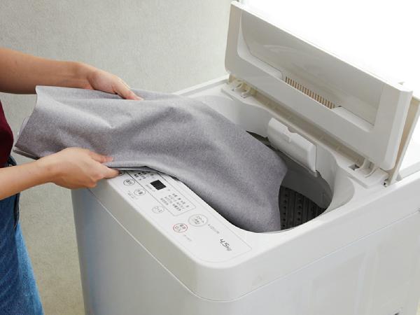 ウォッシャブルロールスクリーンの生地を洗濯機に入れる様子